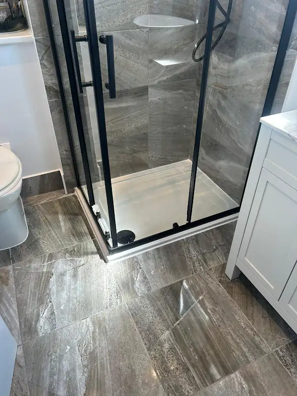 New shower tray with black framed glass screen