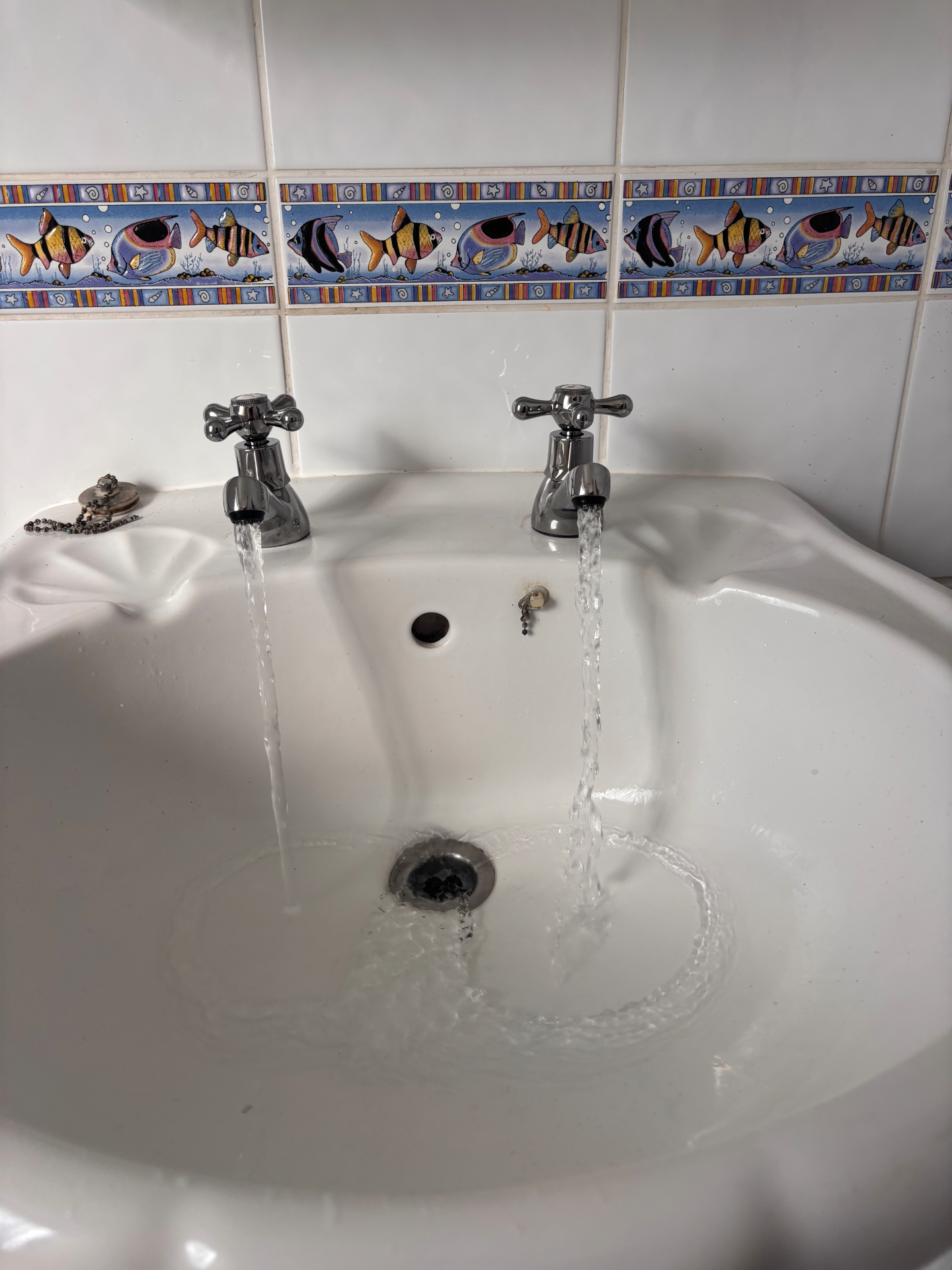 New chrome basin taps with water running