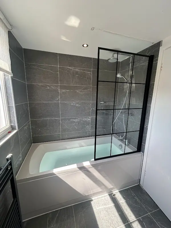 New bath with black framed glass shower screen