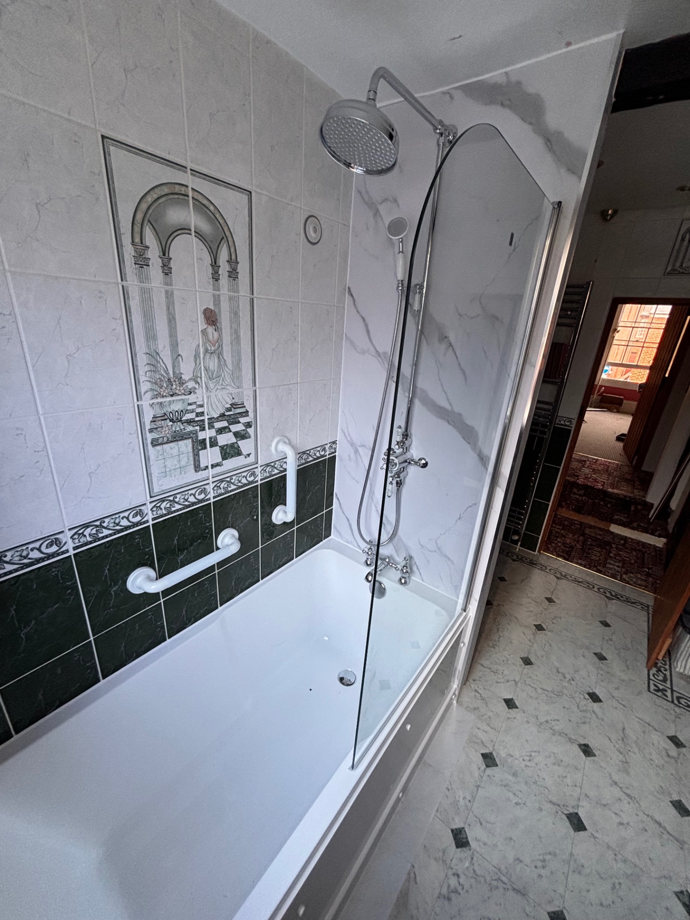 Bath with traditional chrome shower and curved glass screen