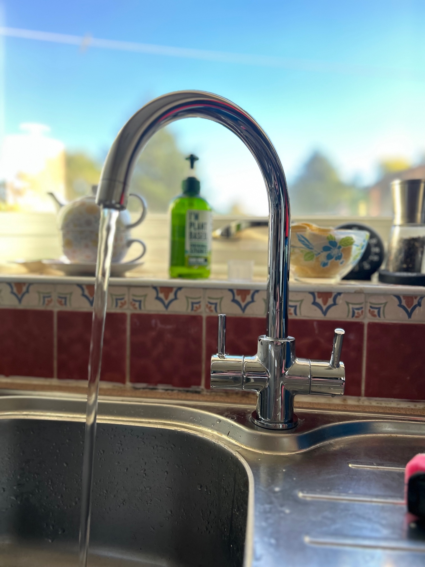 New chrome kitchen mixer tap with water running