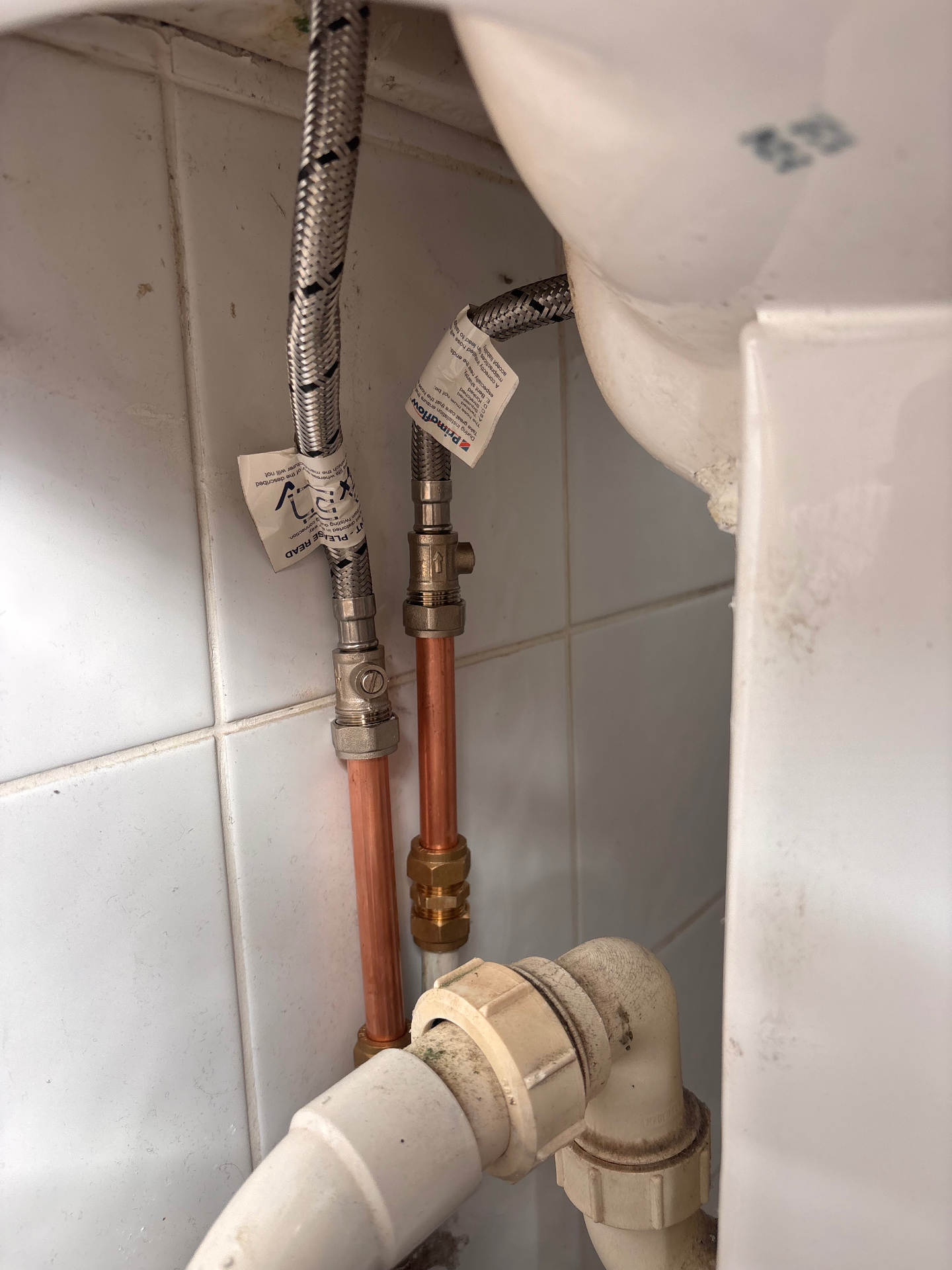 New copper pipework and isolation valves fitted beneath a basin